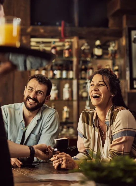 cheerful-friends-having-fun-while-talking-waiter-cafe