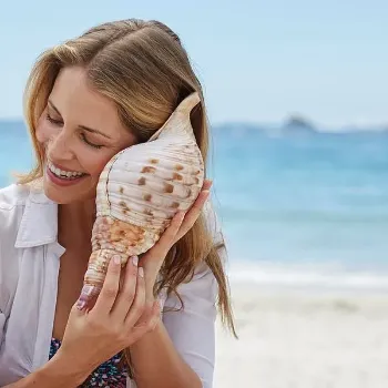 woman-listening-to-a-seashell-science-photo-library